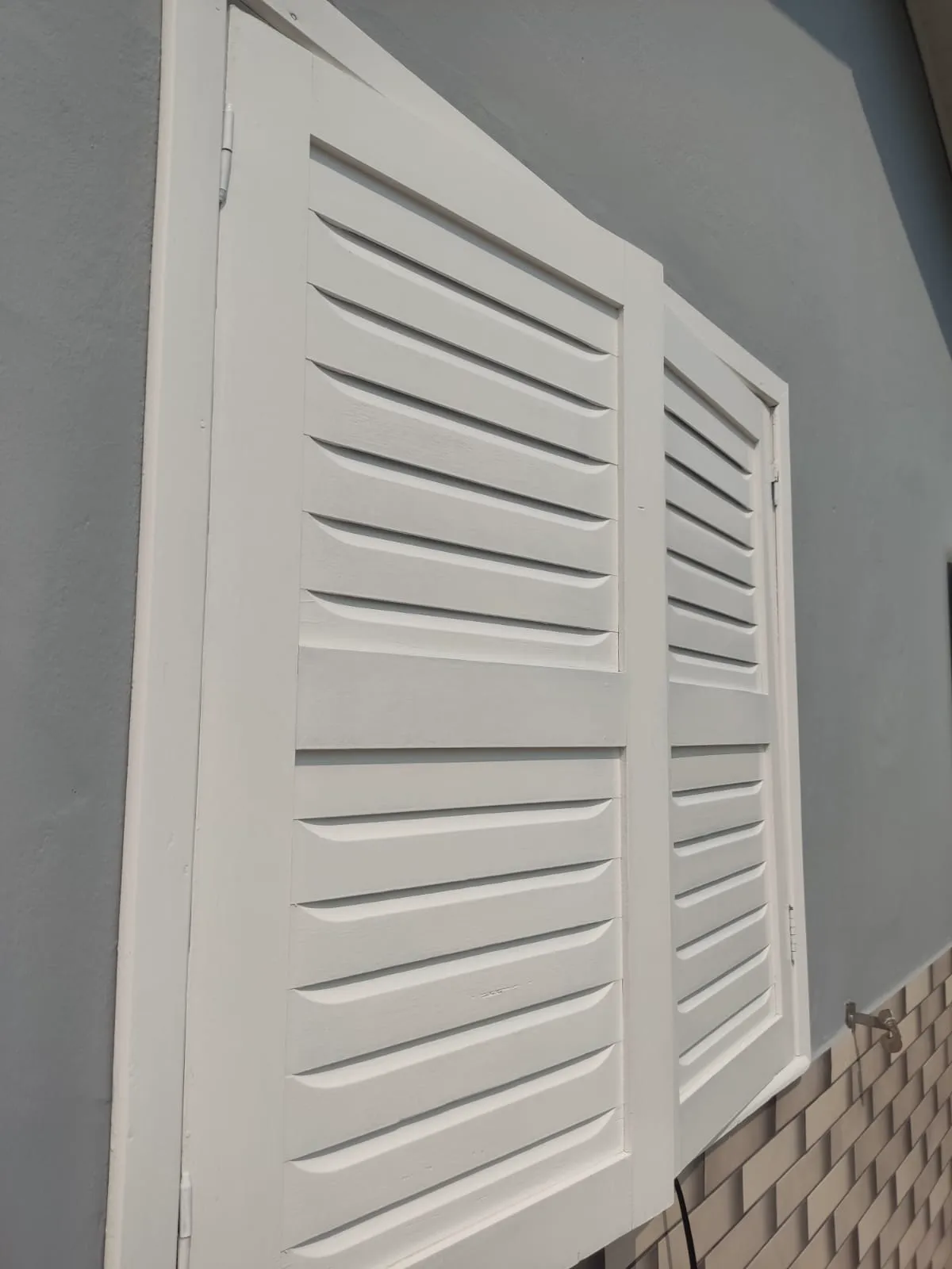Porta veneziana branca após pintura